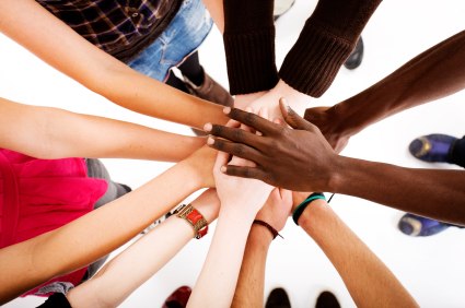 children standing in a circle with hands meeting in the centre